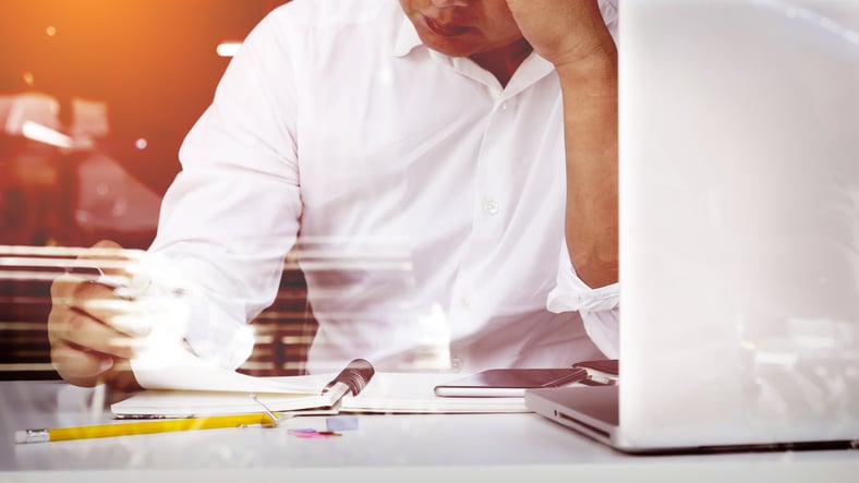 business-man-seated-home-office-space-looking-report