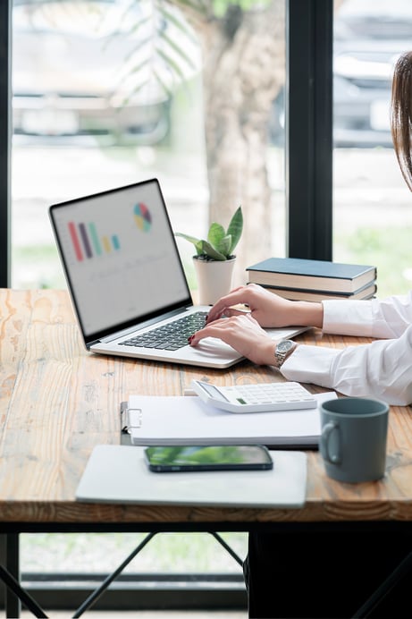 cropped-shot-woman-hand-working-laptop-computer-while-sitting-table-office-room-vertical-view