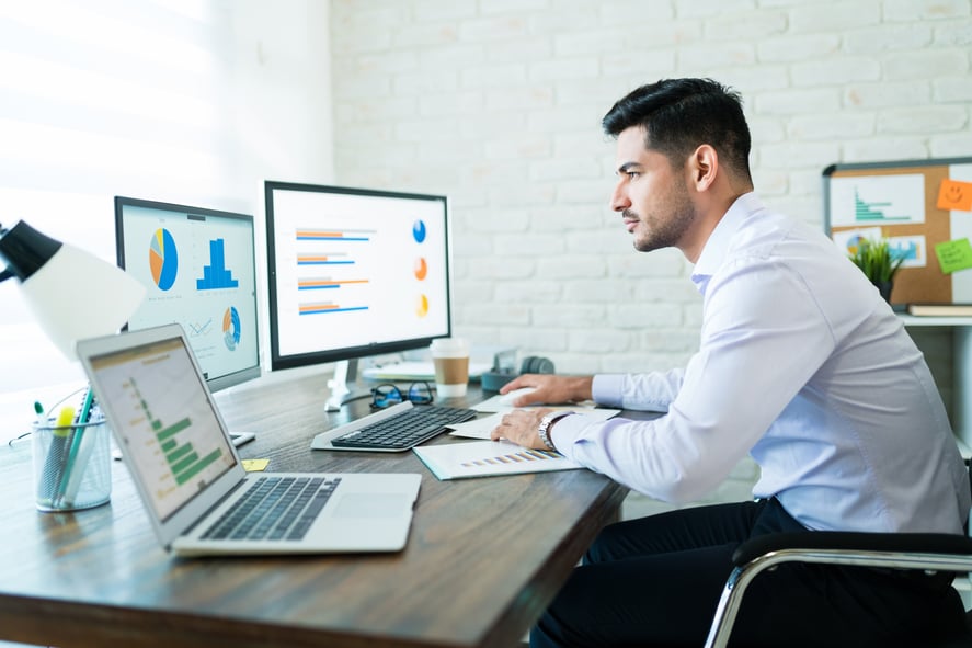 side-view-young-attractive-businessman-studying-charts-computer-while-working-home